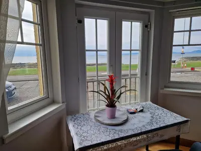 a table with a plant on it in a room with windows at Seaview Retreat in Troon