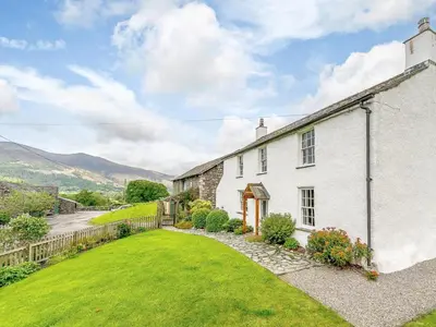 an exterior view of a white house with a yard at 4 Bed in Nr Keswick oc-sz231 in Braithwaite
