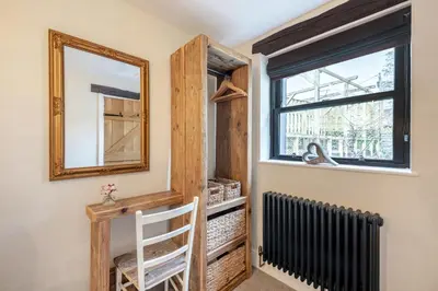 a mirror on a wall next to a window and a radiator at 1 Bed in Uldale oc-g34032 in Uldale