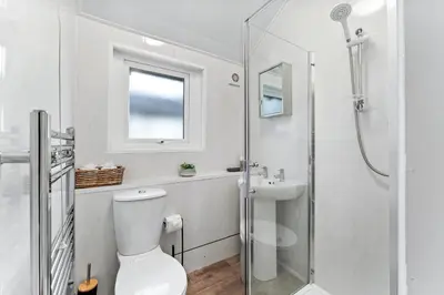 a white bathroom with a toilet and a shower at Newlands House - Quiet Keswick Retreat with Stunning Fell Views, Walk to Town in Keswick