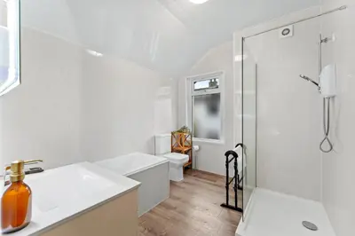 a white bathroom with a shower and a sink at Newlands House - Quiet Keswick Retreat with Stunning Fell Views, Walk to Town in Keswick