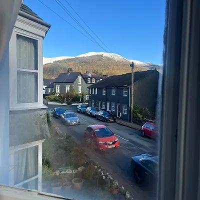 a view from a window of a street with parked cars at Newlands House - Quiet Keswick Retreat with Stunning Fell Views, Walk to Town in Keswick