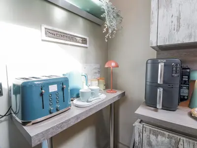 a counter with a microwave and a coffee maker on it at Scotia At The Brig in Annan