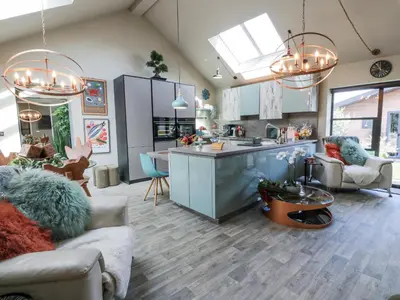 a kitchen and living room with blue cabinets and a island at Scotia At The Brig in Annan
