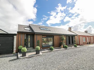 a store front of a house on a gravel driveway at Scotia At The Brig in Annan