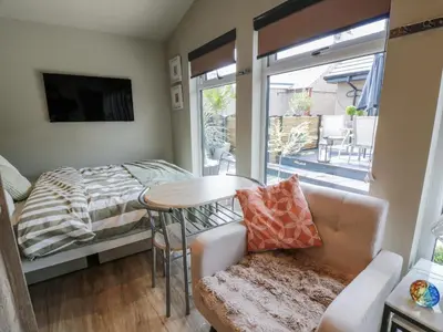 a living room with a couch and a bed and a table at Cabin At The Brig in Annan