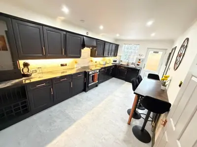 a kitchen with black cabinets and a table at Seaside Retreat in Harrington