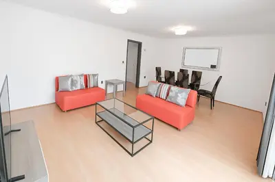 a living room with two red chairs and a table at 3 Bedroom Cozy House-Short and Long Stay in Moffat