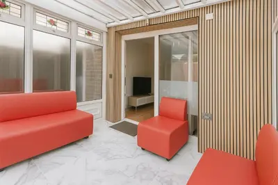 a living room with red chairs and a television at 3 Bedroom Cozy House-Short and Long Stay in Moffat