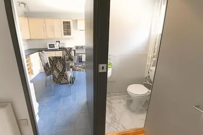 a bathroom with a toilet and a kitchen with a table at 3 Bedroom Cozy House-Short and Long Stay in Moffat
