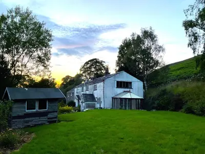 a large white building in a field with a yard at 5 Bed in Wigton oc-b34111 in Caldbeck