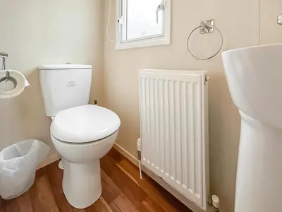 a bathroom with a white toilet and a radiator at Kjs Holiday Haven in Ayr