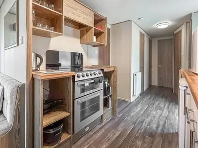 a kitchen with a stove and a microwave at Kjs Holiday Haven in Ayr