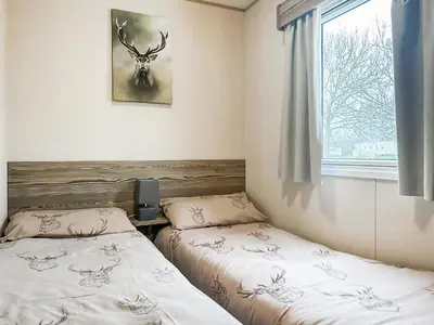 two beds in a room with a window at Kjs Holiday Haven in Ayr