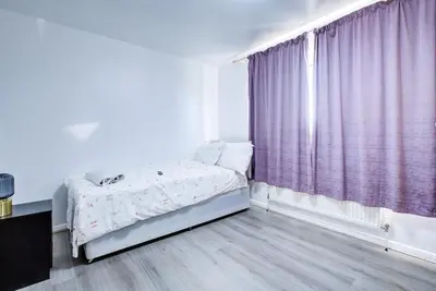 a bedroom with a bed and a window with purple curtains at Southend perfect Stays in Moffat