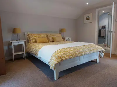 a bedroom with a bed and two tables with lamps at The Coach House- Canonbie in Canonbie