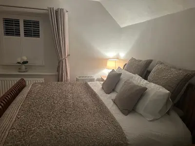 a bedroom with a large bed with white pillows at The Oldest House Located in the heart of Matlock in Moffat