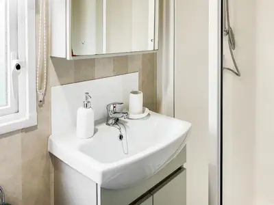 a bathroom with a white sink and a mirror at H And D Greenan Village in Ayr