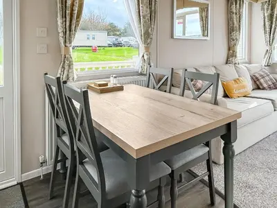 a dining room table with chairs and a couch at Rorys Retreat - Ukc7144 in Ayr