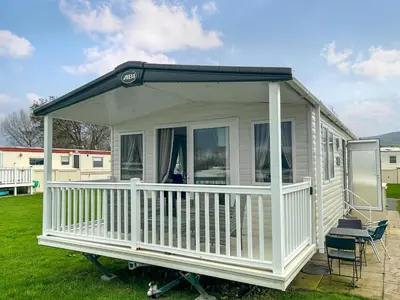 a white house with a porch and a chair at Ocean Bay View - Ukc7143 in Ayr