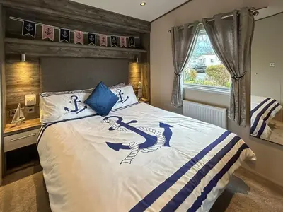 a bedroom with a bed with blue and white sheets at Ocean Bay View - Ukc7143 in Ayr