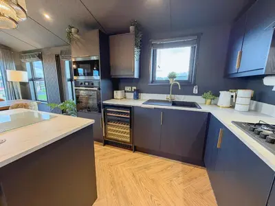 a kitchen with blue cabinets and a counter top at Blackthorn Timber Lodge in Bothel