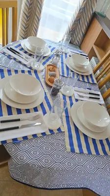 a table with plates and utensils on a blue and white table cloth at Ruby Atlas Monreith in Monreith