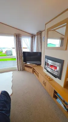 a living room with a tv and a large mirror at Ruby Atlas Monreith in Monreith