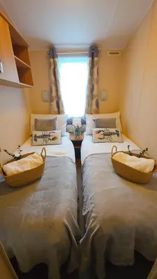 two twin beds in a room with a window at Ruby Atlas Monreith in Monreith