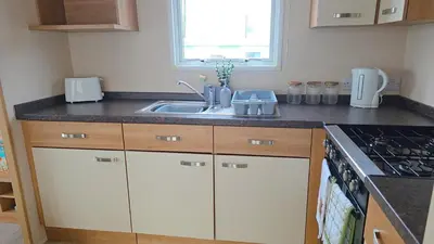 a kitchen with a sink and a stove at Ruby Atlas Monreith in Monreith