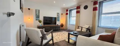 a living room with a couch and a television at The Spacious Urban Retreat in Douglas