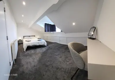 a attic bedroom with a bed and a window at The Spacious Urban Retreat in Douglas
