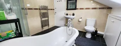 a bathroom with a bath tub and a toilet at The Spacious Urban Retreat in Douglas