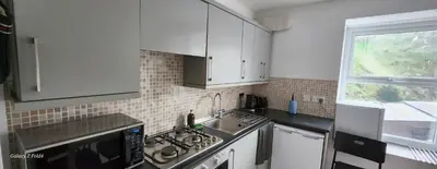 a kitchen with white cabinets and a sink and a window at The Spacious Urban Retreat in Douglas
