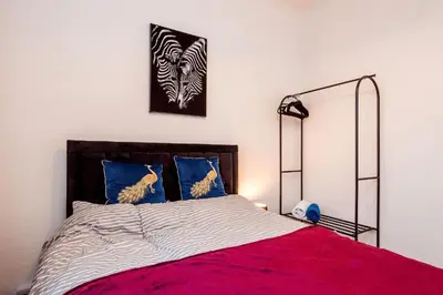 a bedroom with a bed with a red blanket and blue pillows at Mid Street Retreat, Steps from the Beach, Whitehaven in Whitehaven