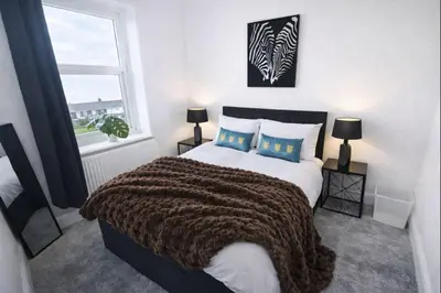a bedroom with a large bed and a window at Mid Street Retreat, Steps from the Beach, Whitehaven in Whitehaven