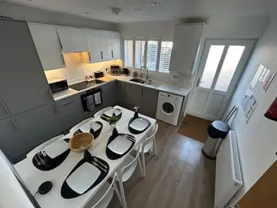 a kitchen with a white table and white chairs at Beach Stroll Retreat, Swanage, Dorset in Moffat