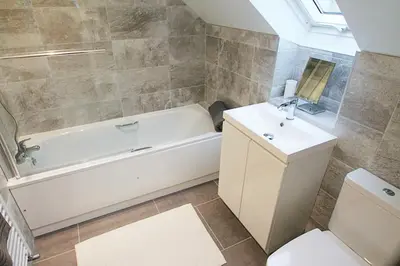 a bathroom with a tub and a toilet and a sink at Beach Stroll Retreat, Swanage, Dorset in Moffat
