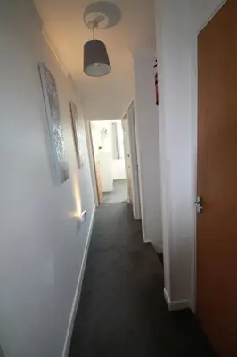 a hallway with white walls and a hallway with at Beach Stroll Retreat, Swanage, Dorset in Moffat