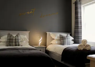 a bedroom with two beds and a sign that reads sweet things at Azalea in Keswick