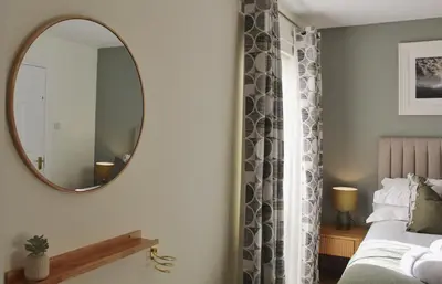 a bedroom with a mirror and a bed at Azalea in Keswick