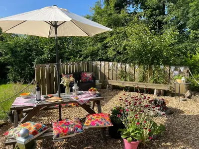 a picnic table with an umbrella in a garden at Handy for Lake District, detached property in Penruddock