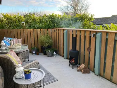 a patio with a fireplace and a table and chairs at Handy for Lake District, detached property in Penruddock