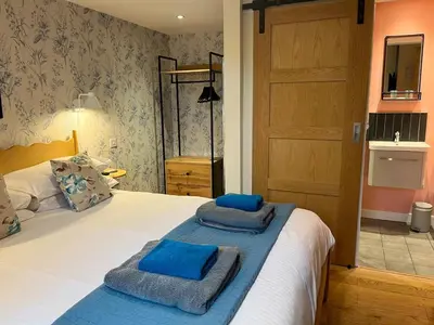 a bedroom with a bed with blue towels on it at Handy for Lake District, detached property in Penruddock