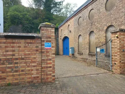 a brick building with a blue door and a gate at Bardywell Penthouse - 2 Bedrooms - Sleeps 4 in Whitehaven