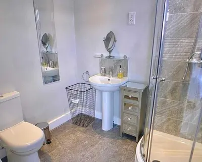 a bathroom with a toilet and a sink and a shower at Bardywell Penthouse - 2 Bedrooms - Sleeps 4 in Whitehaven