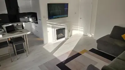 a living room with a fireplace and a tv on the wall at Exceptional 1 bedroom riverside 2E apartment in Ayr