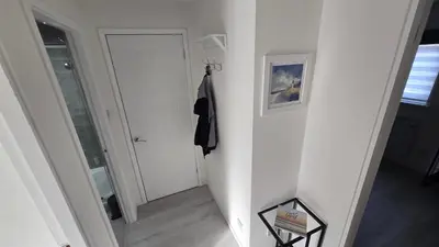 a hallway with a white door and a coat hanging at Exceptional 1 bedroom riverside 2E apartment in Ayr