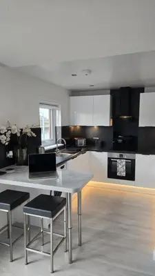 a kitchen with a table and two chairs in it at Exceptional 1 bedroom riverside 2E apartment in Ayr
