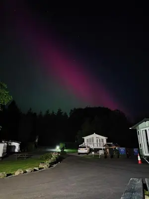 a rainbow in the sky over a parking lot at Barrhill Holiday Park - Glamping in South West Scotland - Stinchar in Girvan